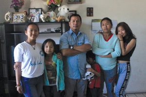 NEW BEGINNINGS: Dambar Magar a former refugee from Bhutan with his wife and daughters in their apartment in Oakland, California.